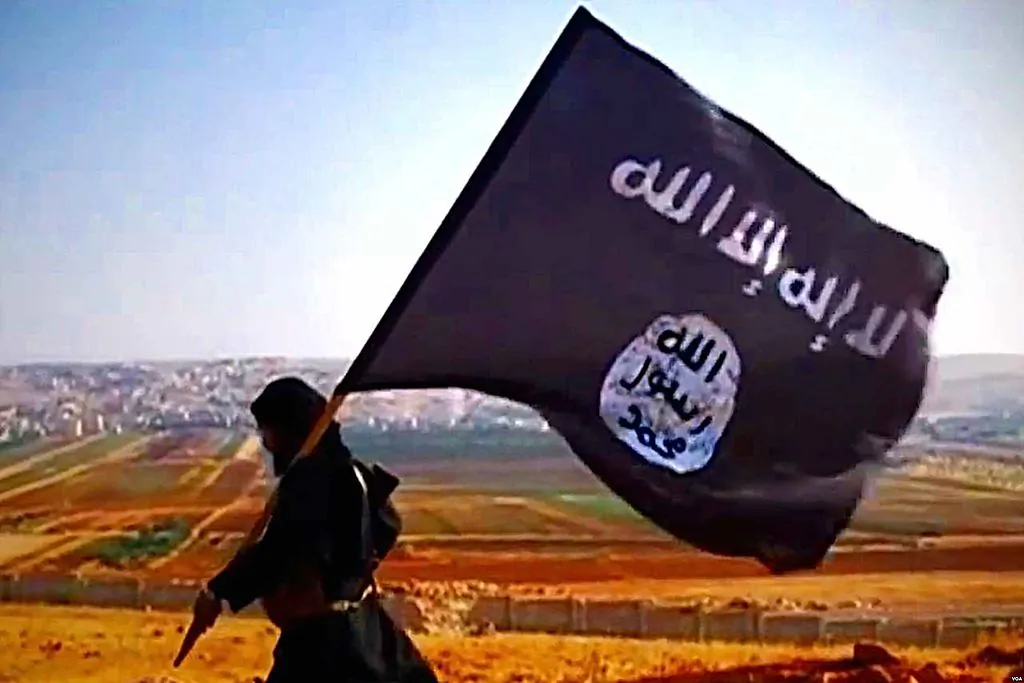 A member of the ISIS terrorist group carried the ISIS banner. (By VOA [Public domain], via Wikimedia Commons)