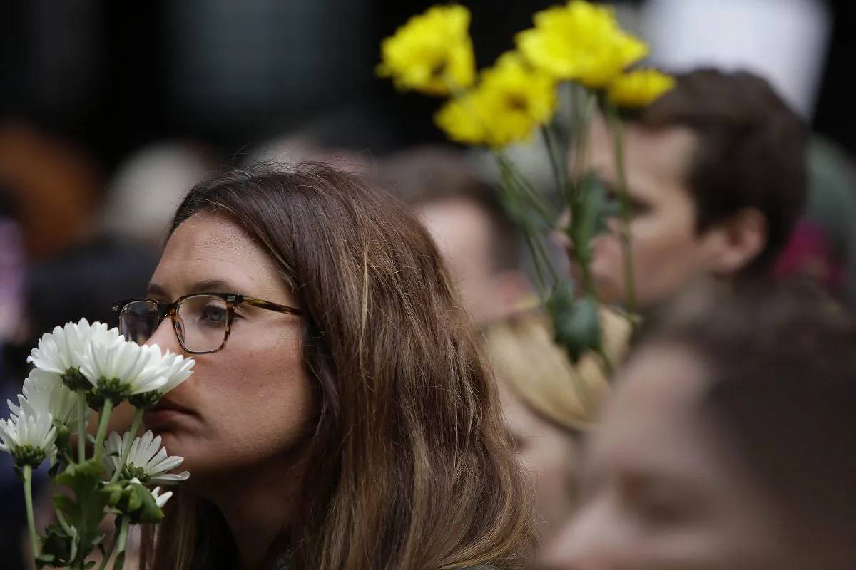 People hold flowers at a vigil in Chicago on Aug. 13 a day after a call drove into a crowd at a protest in Charlottesville killing 32-year-old Heather Heyer. (JOSHUA LOTT/AFP/Getty Images)