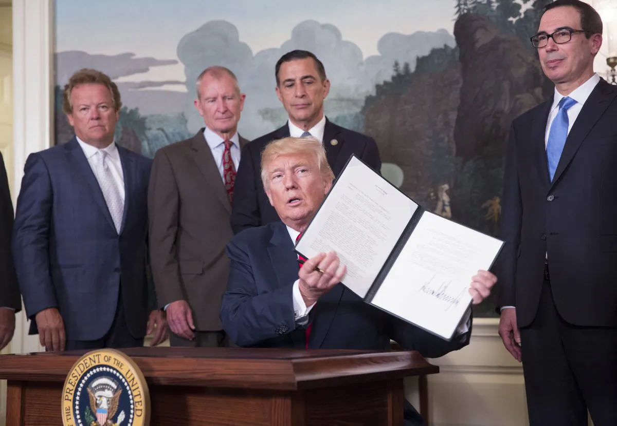 President Donald J. Trump signs a memorandum on addressing China's laws, policies, practices, and actions related to intellectual property, innovation, and technology at The White House in Washington on Aug. 14, 2017.  (Chris Kleponis-Pool/Getty Images)