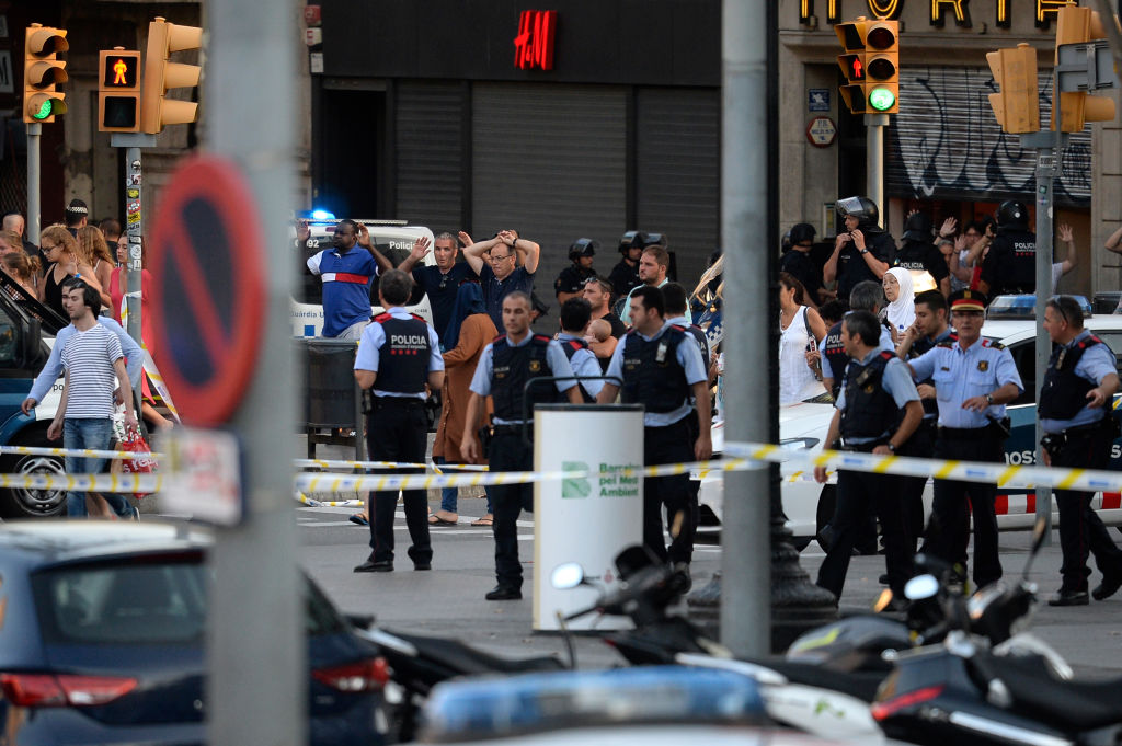 People stand with hands up as asked by policemen after a van ploughed into the crowd, killing two persons and injuring several others on the Rambla in Barcelona on August 17, 2017. (JOSEP LAGO/AFP/Getty Images)