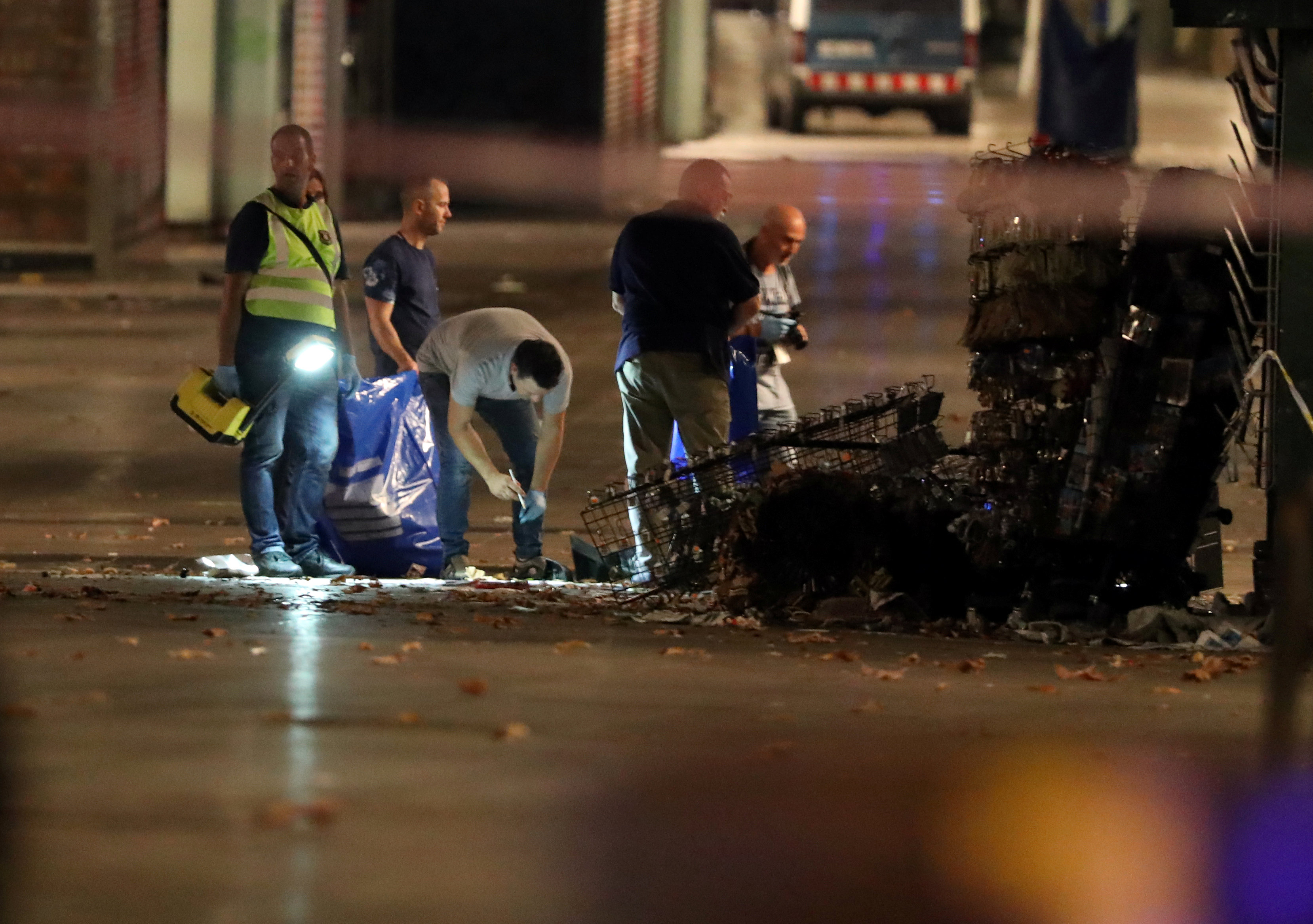 Forensic police officers search for clues near the area where a van crashed into pedestrians at Las Ramblas in Barcelona, Spain, August 18, 2017. (REUTERS/Sergio Perez)