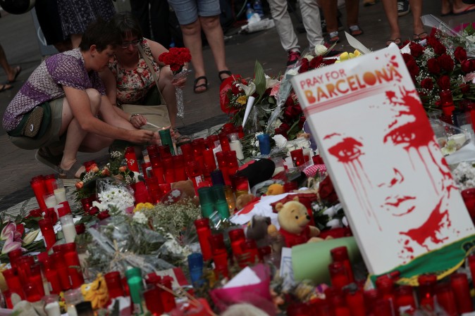 Two women light a candle at an impromptu memorial where a van crashed into pedestrians at Las Ramblas in Barcelona, Spain, August 19, 2017. (Reuters/Sergio Perez)