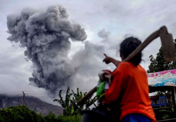 An Indonesian villager gestures as Mount Sinabung volcano spews thick volcanic ash, in Karo, North Sumatra on July 8, 2017. (AFP/Getty Images)