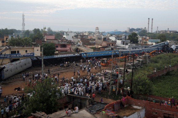 Rescue workers and onlookers stand next to derailed coaches of a passenger train at the site of an accident in Khatauli, in the northern state of Uttar Pradesh, India August 20, 2017. (Reuters/Adnan Abidi)