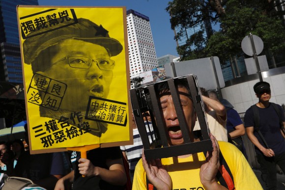 A demonstrator holds cardboard jail bars, as he protests of the jailing of student leaders Joshua Wong, Nathan Law and Alex Chow, who were imprisoned for their participation of the 2014 pro-democracy Umbrella Movement, also known as "Occupy Central" protests, in Hong Kong China August 20, 2017. (Reuters/Tyrone Siu)