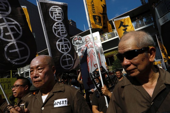 Demonstrators, wearing prison uniforms, march in protest of the jailing of student leaders Joshua Wong, Nathan Law and Alex Chow, who were imprisoned for their participation of the 2014 pro-democracy Umbrella Movement, also known as "Occupy Central" protests, in Hong Kong China August 20, 2017. (Reuters/Tyrone Siu)