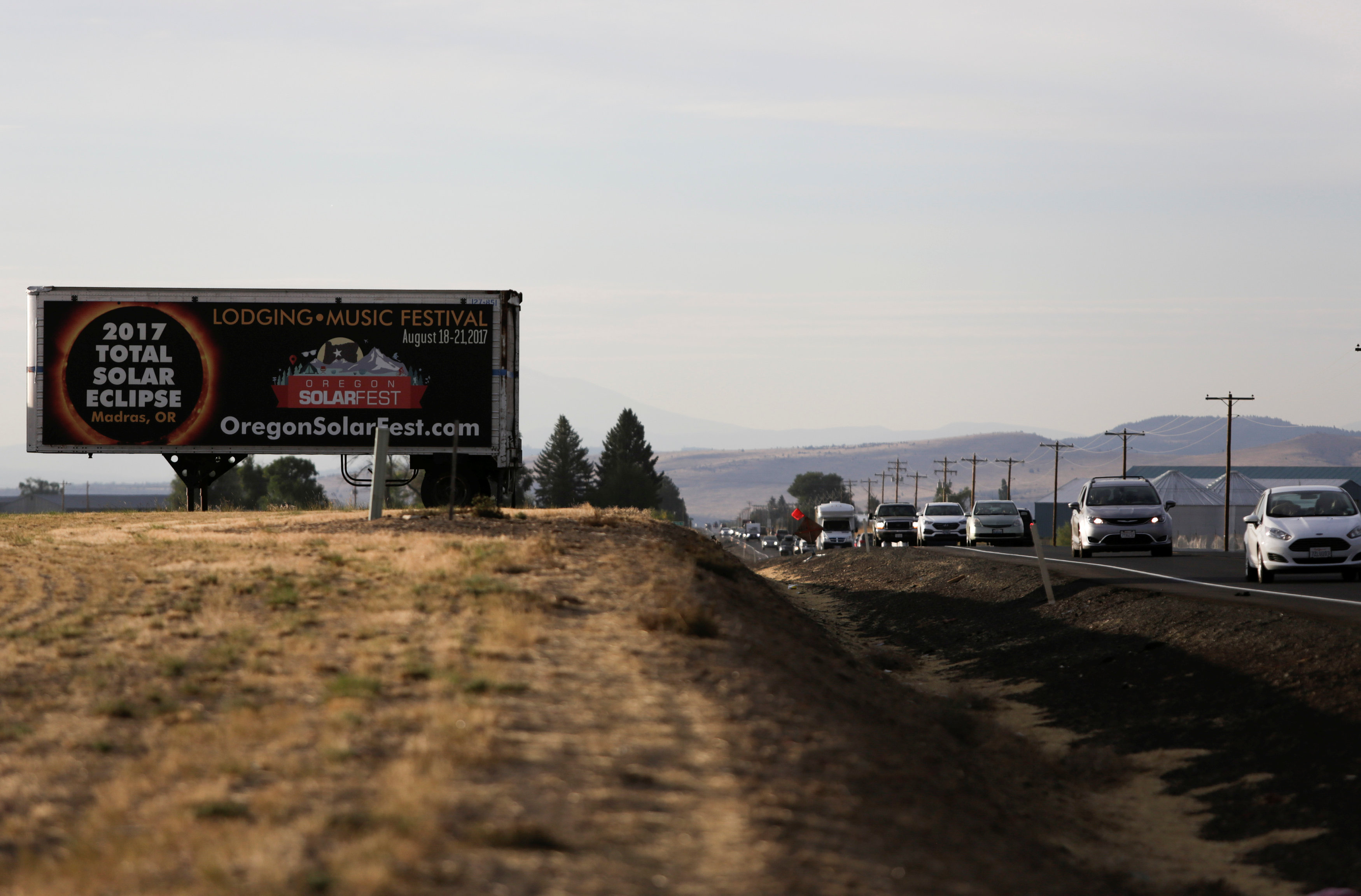 A sign promoting the solar eclipse is pictured as people drive into Madras, Oregon on Aug.20, 2017. (REUTERS/Jason Redmond)