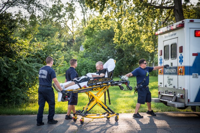 Local police and paramedics help a man who is overdosing in the Drexel neighborhood of Dayton, Ohio, on Aug. 3, 2017. (Benjamin Chasteen/The Epoch Times)