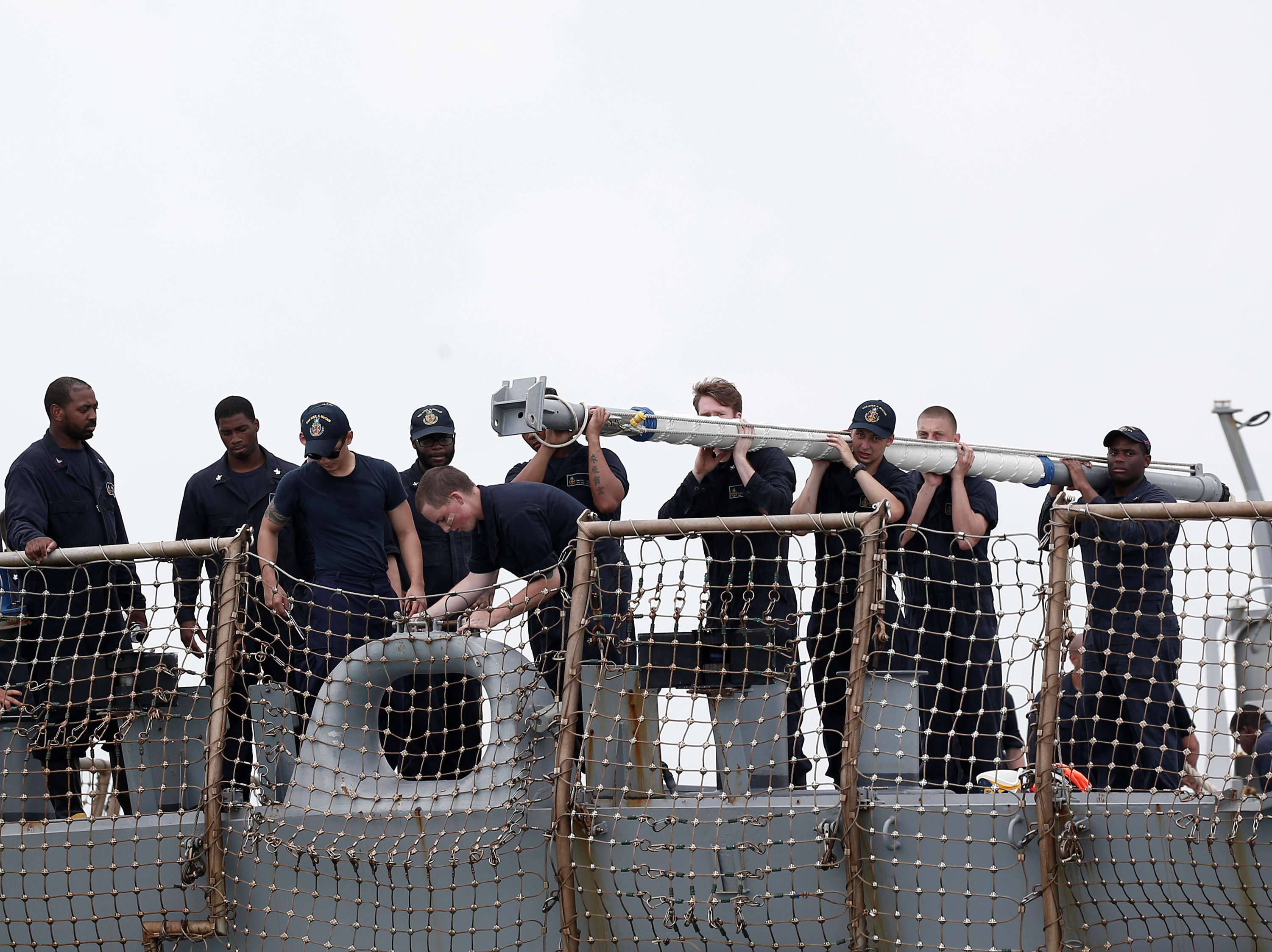 Personnel work on the U.S. Navy guided-missile destroyer USS John S. McCain after a collision, in Singapore waters on August 21, 2017. (REUTERS/Ahmad Masood)