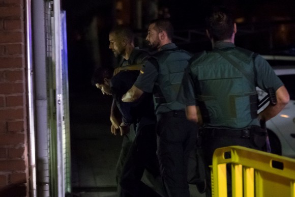 Spanish Civil Guards escort one of four men accused of involvement in an Islamist cell behind a van attack in Barcelona last week, in Tres Cantos, Spain, August 21, 2017. (Reuters/Juan Medina)