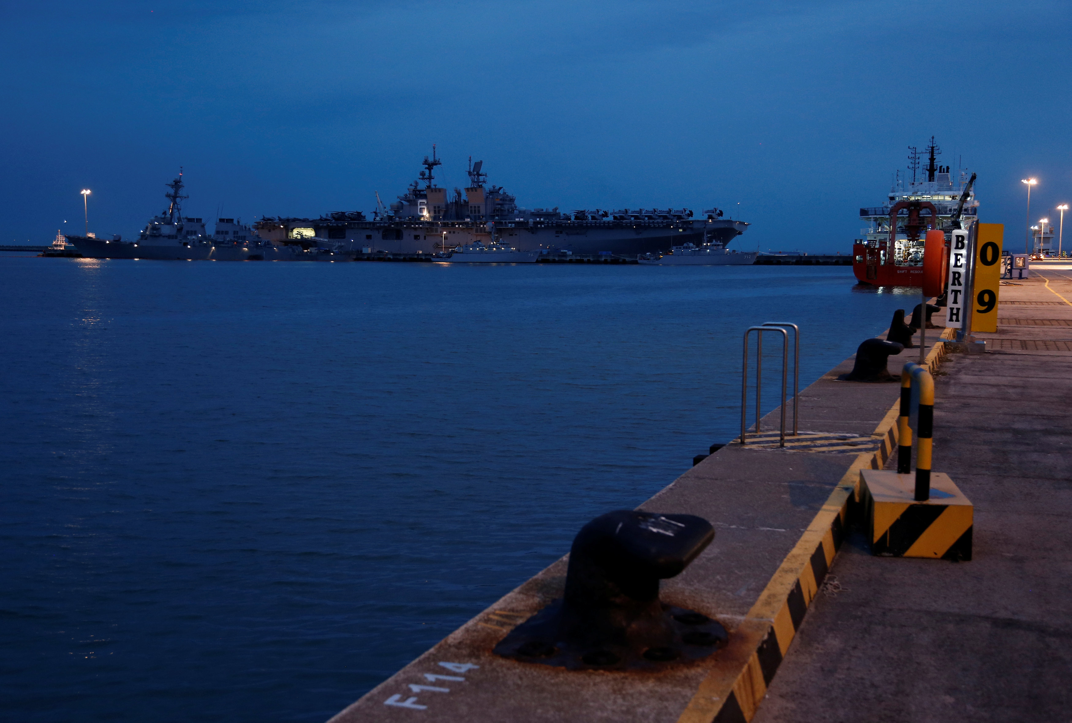 The damaged USS John McCain (L) is docked next to USS America at Changi Naval Base in Singapore on August 22, 2017. (REUTERS/Calvin Wong)