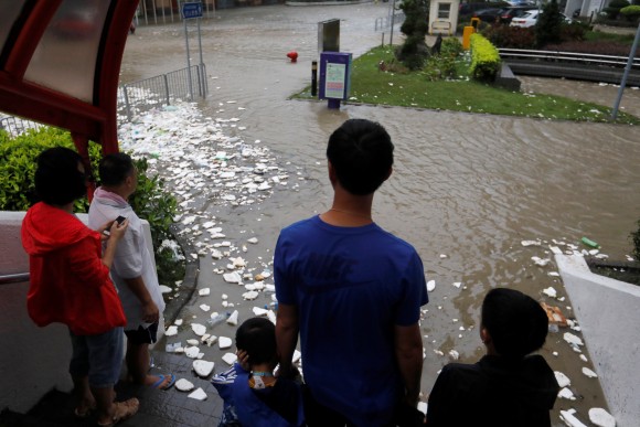 People look at a flooded street as Typhoon Hato hits Hong Kong, China August 23, 2017. (Reuters/Tyrone Siu)