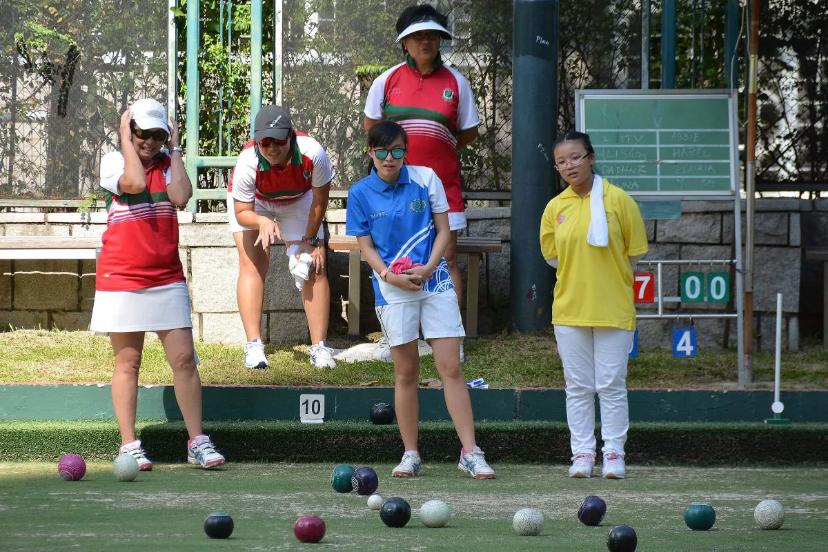 Hazel Lee of the the Young Athletes Lawn Bowls Training Scheme (yellow shirt) played her first competitive game with Gloria Ha of the Hong Kong Youth Team (blue shirt) against experience bowlers from Kowloon Cricket Club last Saturday, Aug 19, 2017, in a funday to kick-start the Bowls Academy Program. (Stephanie Worth)