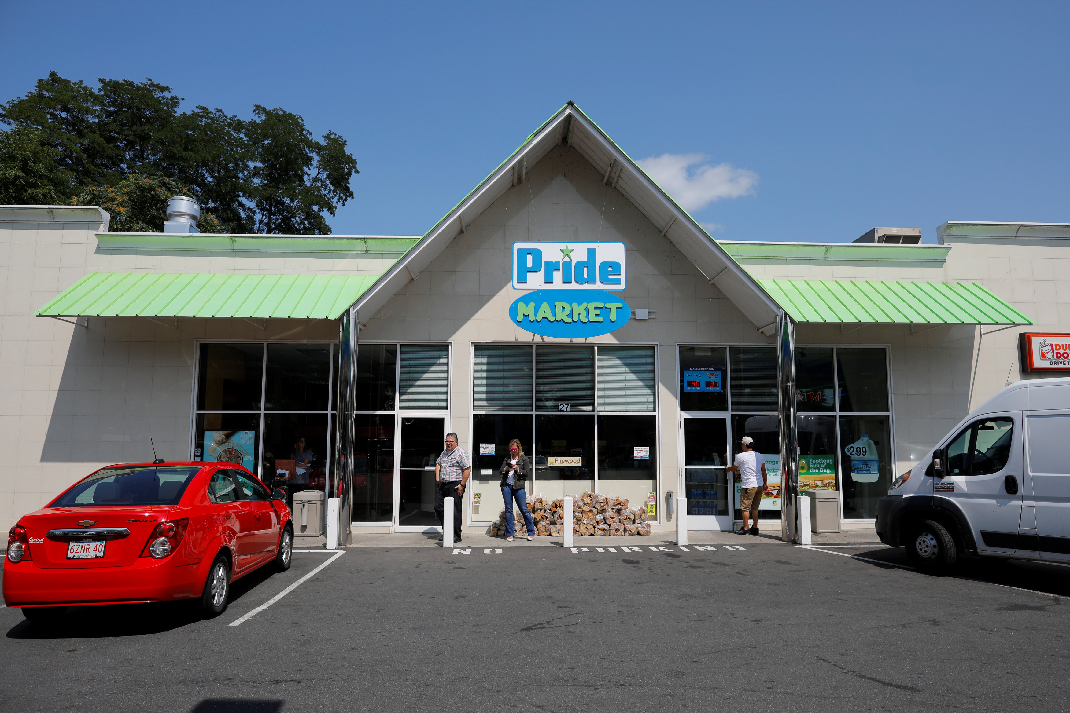 People stand in front of the Pride convenience store where a winning more than $750 million Powerball ticket was sold in Chicopee, Massachusetts, U.S., August 24, 2017. (REUTERS/Brian Snyder)