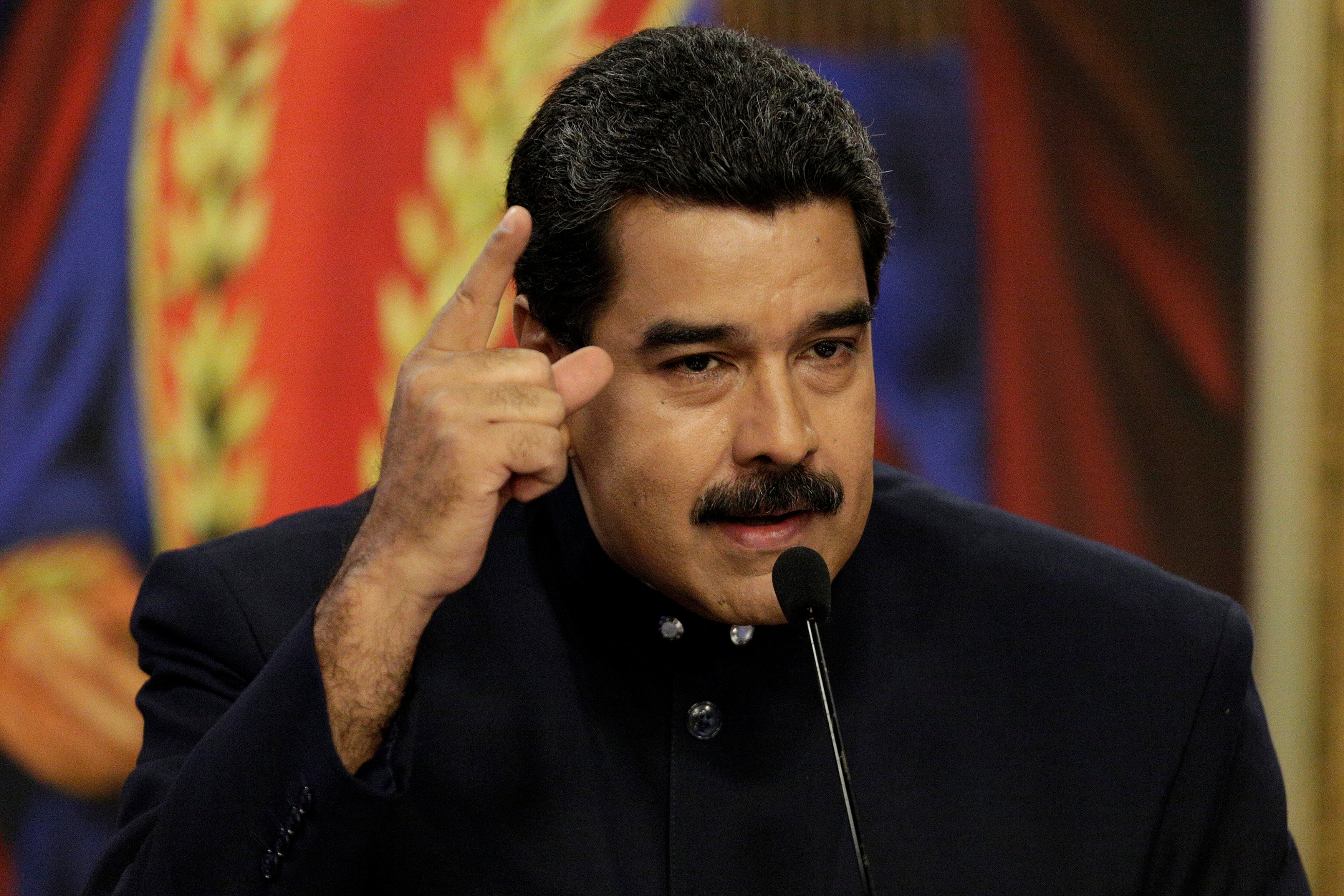 Venezuela's President Nicolas Maduro talks to the media in front of images of Venezuela's national hero Simon Bolivar, during a news conference at Miraflores Palace in Caracas, Venezuela on Aug. 22, 2017. (REUTERS/Marco Bello)