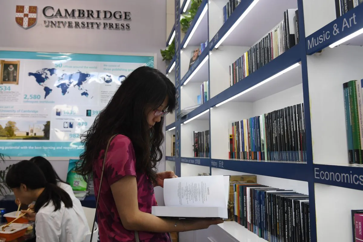 A woman reads a book at the Cambridge University Press stand at the Beijing International Book Fair in Beijing on Aug. 23, 2017. 
Just days after an outcry over an attempt to censor a British academic journal in China, hundreds of international publishing houses are courting importers at a major book fair in Beijing. / AFP PHOTO / Greg Baker / TO GO WITH China-Britain-US-censorship-education, FOCUS by Joanna CHIU        (Photo credit should read GREG BAKER/AFP/Getty Images)