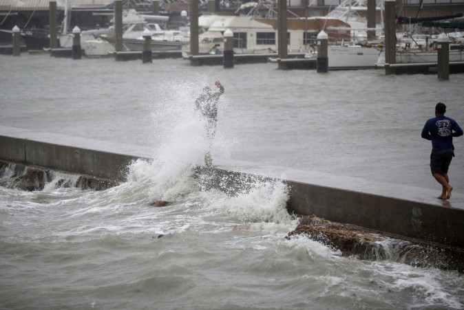 A person is hit by a wave churned up by approaching Hurricane Harvey on August 25, 2017 in Corpus Christi, Texas. Hurricane Harvey has intensified into a hurricane and is aiming for the Texas coast with the potential for up to 3 feet of rain and 125 mph winds. (Photo by Joe Raedle/Getty Images)