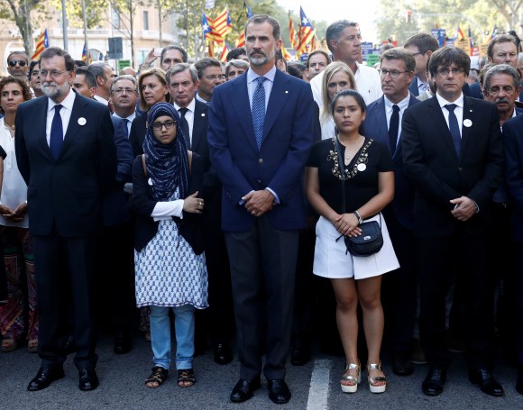 Spain's King Felipe (C), Prime Minister Mariano Rajoy (L) and Catalan regional president Carles Puigdemont (R) take part in a march of unity after the attacks last week, in Barcelona, Spain on Aug. 26, 2017. (REUTERS/Juan Medina)