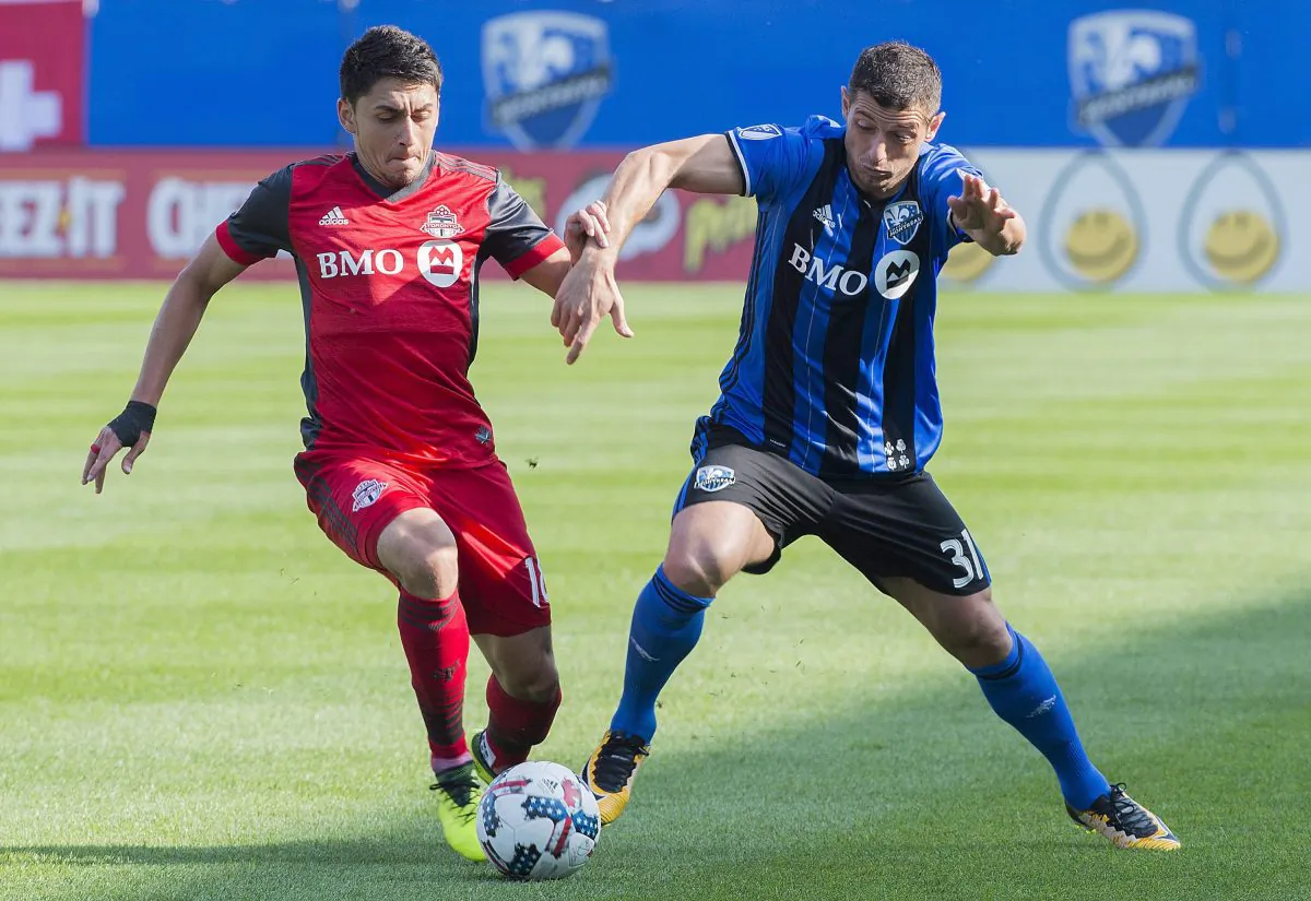 Montreal Impact's Blerim Dzemaili (R) challenges Toronto FC's Marky Delgado at Stade Saputo in Montreal on Aug. 27, 2017. TFC extended its unbeaten streak to nine games with the important win on the road. (The Canadian Press/Graham Hughes)
