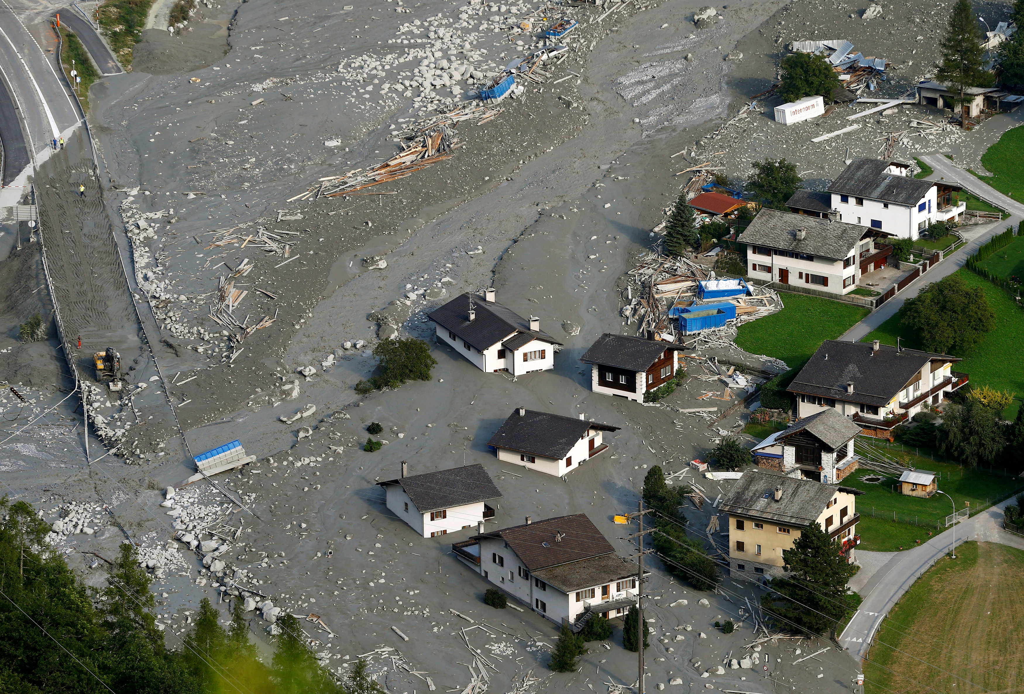 Houses are surrounded by debris of a landslide in the village of Bondo on Aug.26, 2017.  (REUTERS/Arnd Wiegmann)