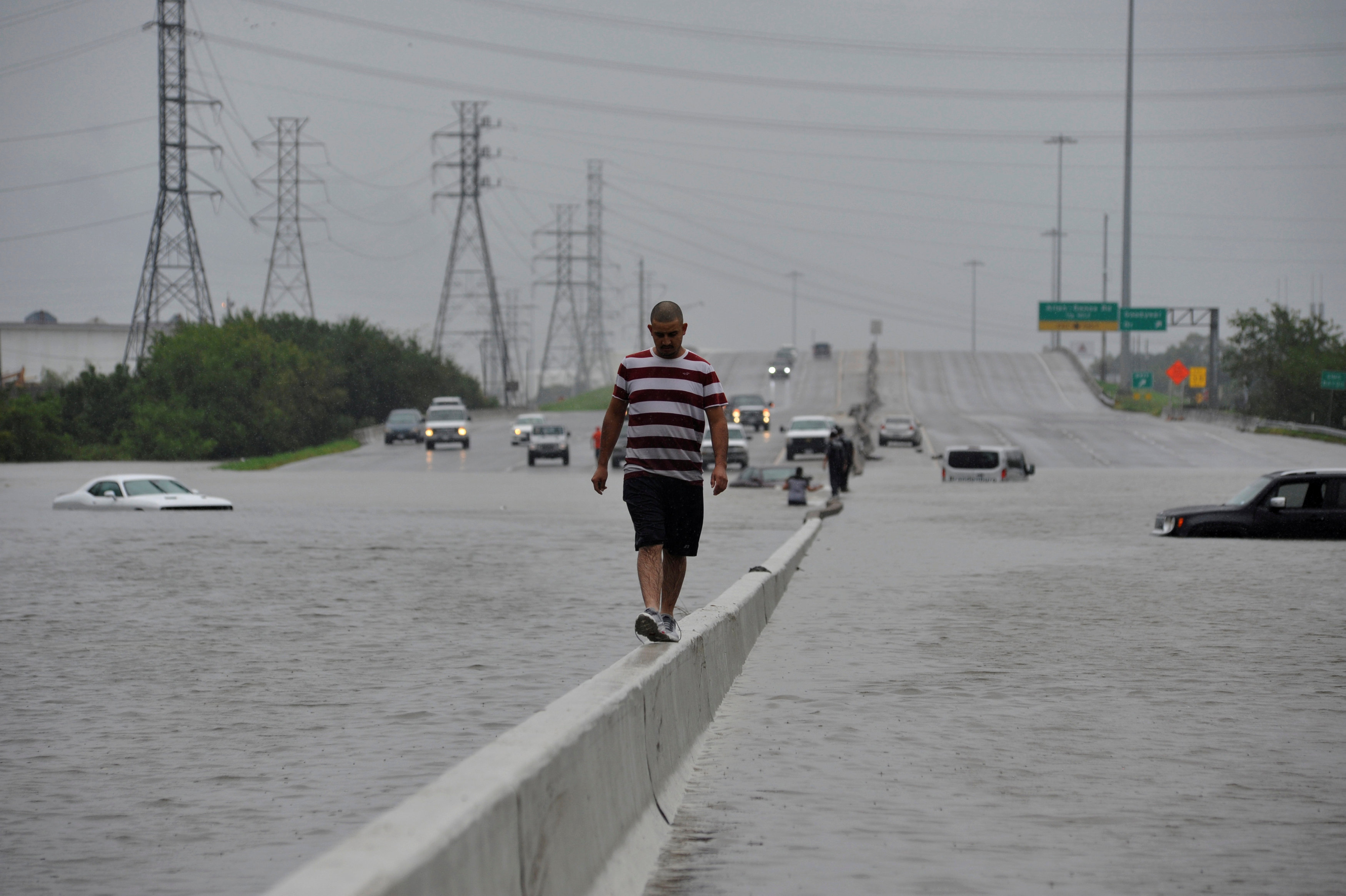 A stranded motorist escapes floodwaters on Interstate 225 after Hurricane Harvey inundated the Texas Gulf coast with rain causing mass flooding, in Houston, Texas, U.S. on Aug. 27, 2017.  (REUTERS/Nick Oxford)