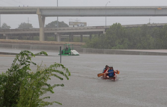 Area residents use a kayak to rescue motorists stranded on Interstate highway 45 which is submerged from the effects of Hurricane Harvey seen during widespread flooding in Houston, Texas, U.S. on Aug. 27, 2017. (REUTERS/Richard Carson)