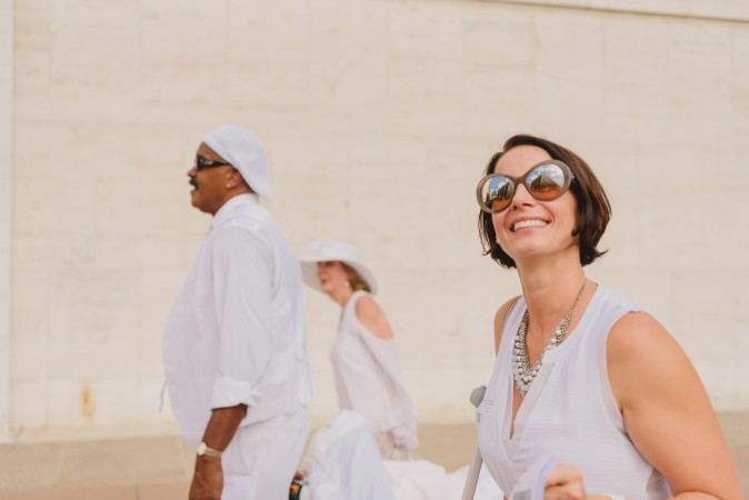 Guests walk to the location of the annual Diner en Blanc in New York on Aug. 22, 2017. Diner en Blanc began in France nearly 30 years ago and is held around the world. (Light Feather for Diner en Blanc) 