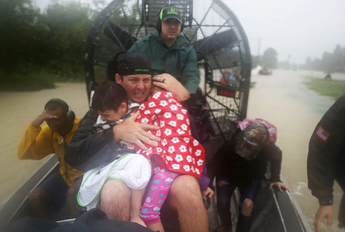 Volunteer Dean Mize  holds children as he and Jason Legnon use an airboat to rescue people from homes that are inundated with flooding from Hurricane Harvey in Houston, Texas on Aug. 28, 2017. (Joe Raedle/Getty Images)