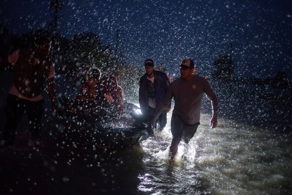 Samaritans help push a boat with evacuees to high ground during a rain storm caused by Tropical Storm Harvey along Tidwell Road in east Houston, Texas, U.S. August 28, 2017. (Reuters/Adrees Latif)