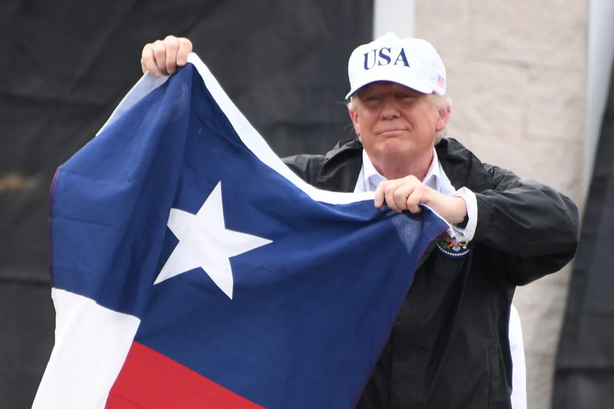 Then-President Donald Trump holds a Texas state flag outside of a fire house in Corpus Christi, Texas, on Aug. 29, 2017. (Jim Watson/AFP/Getty Images)