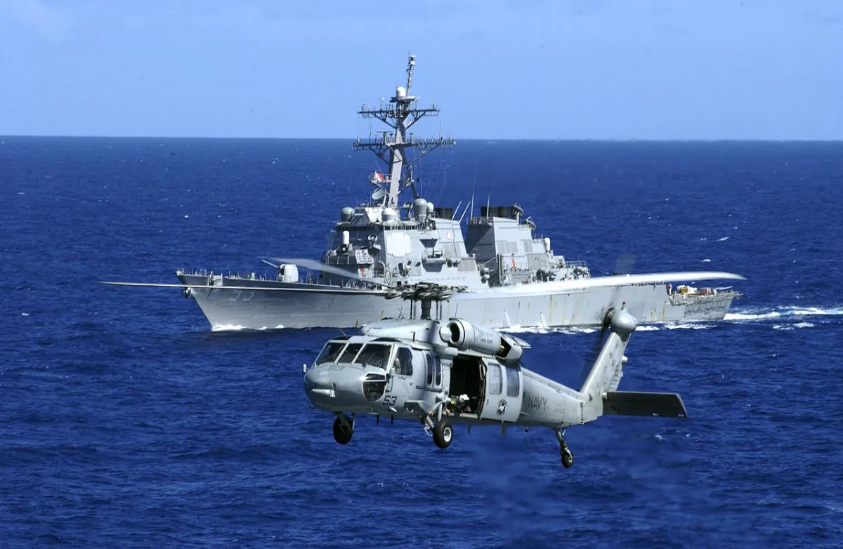 An MH-60S Seahawk flies near the guided missile destroyer USS John Paul Jones (DDG 53) during a vertical replenishment.  On Aug 30, the John Paul shot down a medium range ballistic missile during a test exercise off the coast of Hawaii. (Airman Dylan Butler/U.S. Navy)