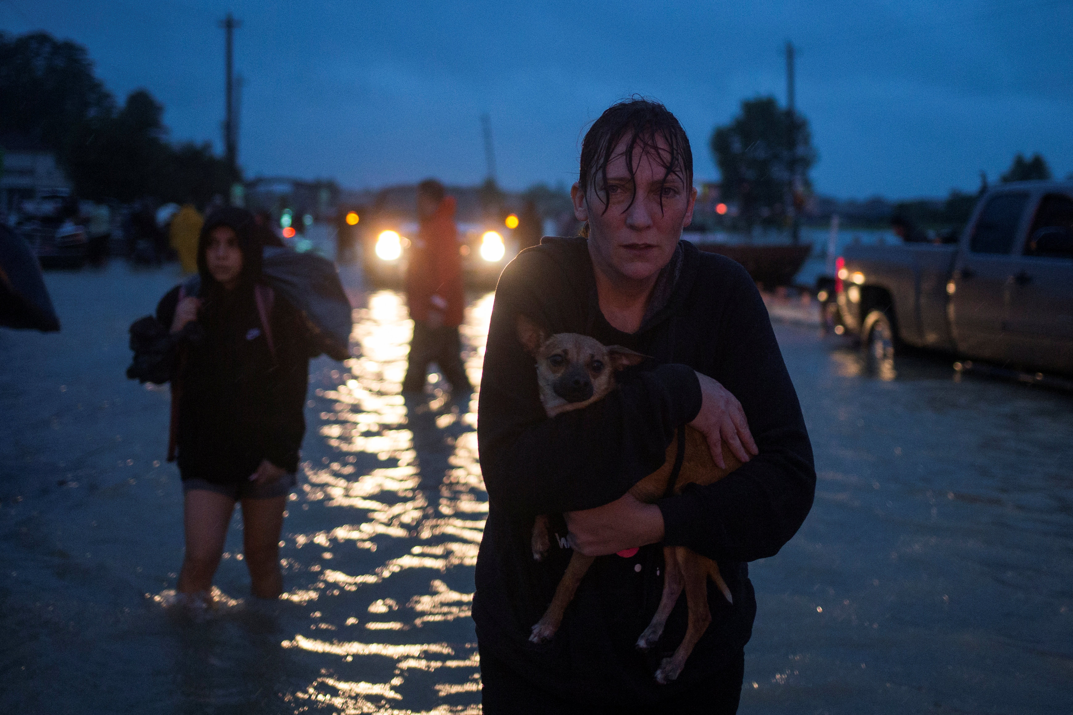A woman holds her dog as she arrives to high ground after evacuating her home due to floods caused by Tropical Storm Harvey along Tidwell Road in east Houston, Texas on August 28, 2017. (Reuters/Adrees Latif)