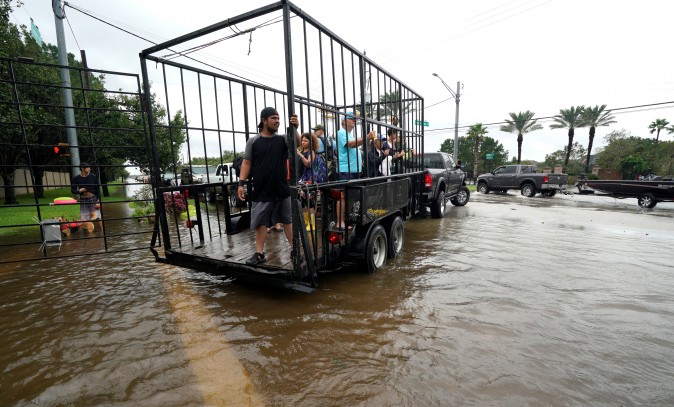 A group of people are shuttled to dry ground in a trailer after being evacuated by boat from the Hurricane Harvey floodwaters in Houston, Texas August 29, 2017. (Reuters/Rick Wilking)