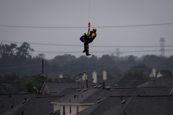 A military helicopter and personnel rescue a stranded resident from floods caused by Tropical Storm Harvey in east Houston, Texas, U.S. August 29, 2017. (Reuters/Adrees Latif)