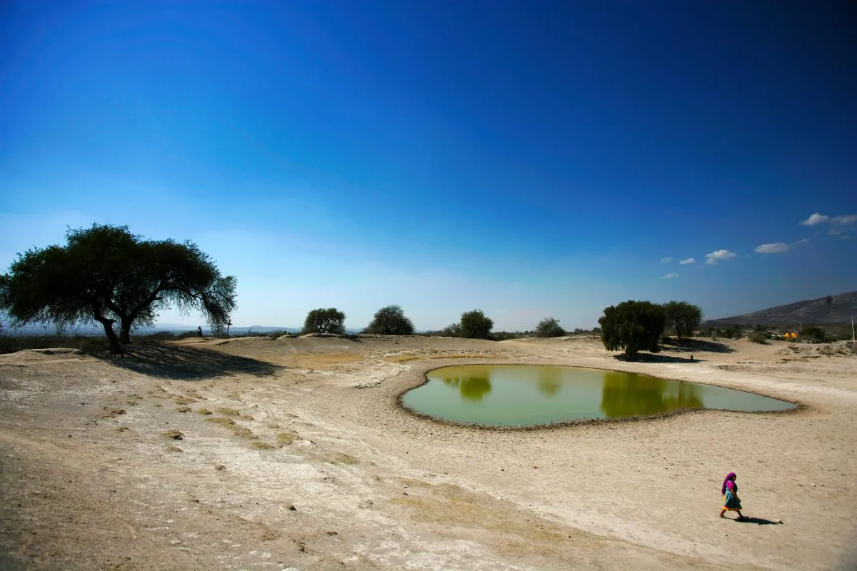 A Mexican woman skirts a Jaguey water hole, Feb. 4, 2006, near San Marcos Tlacoyalco. The Tehuacan Valley south-east of Mexico City has long experienced severe water shortages. Water resources in the area area are largely based on a weekly delivery by truck as well as collecting water from small pools known as Jagueys. This collected water was traditionally only used for animals but now more and more people are relying on it as a water source for crops and for drinking and bathing purposes. (Brent Stirton/Getty Images)