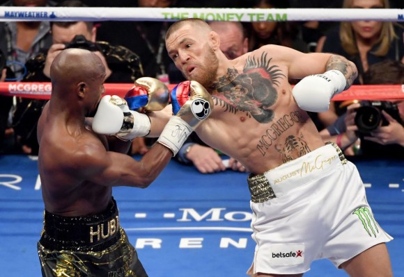 Conor McGregor (R) throws a right at Floyd Mayweather Jr. in the second round of their super welterweight boxing match at T-Mobile Arena on August 26, 2017 in Las Vegas, Nevada. Mayweather won by 10th-round TKO. (Photo by Ethan Miller/Getty Images)