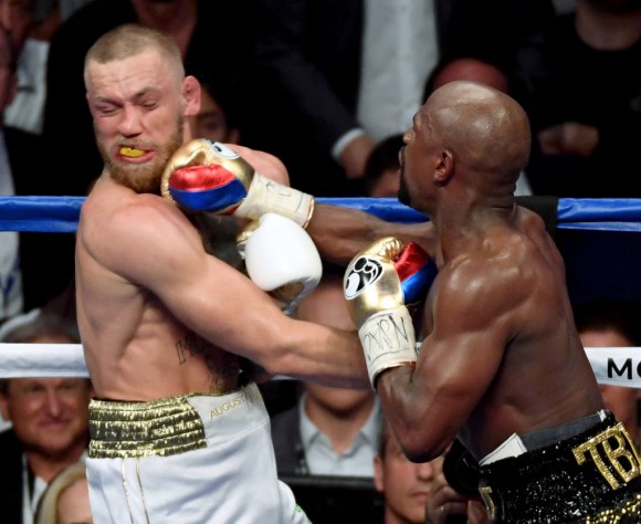 Floyd Mayweather Jr. (R) hits Conor McGregor with a right in the 10th round of their super welterweight boxing match at T-Mobile Arena on August 26, 2017 in Las Vegas, Nevada. (Photo by Ethan Miller/Getty Images)