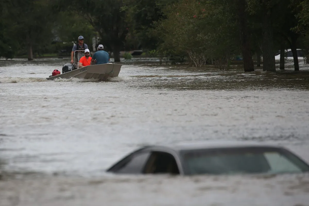 A rescue boat evacuates people from the rising waters of Buffalo Bayou following Hurricane Harvey in a neighborhood west of Houston, Texas, U.S., August 30, 2017. Vehicles quicly become death traps in flood conditions, warn authorities. REUTERS/Carlo Allegri