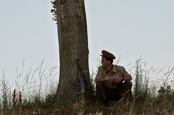 A North Korean soldier takes a break and sits near a tree on the banks of the Yalu river near Sinuiju, opposite the Chinese border city of Dandong on July 5, 2017. (NICOLAS ASFOURI/AFP/Getty Images)