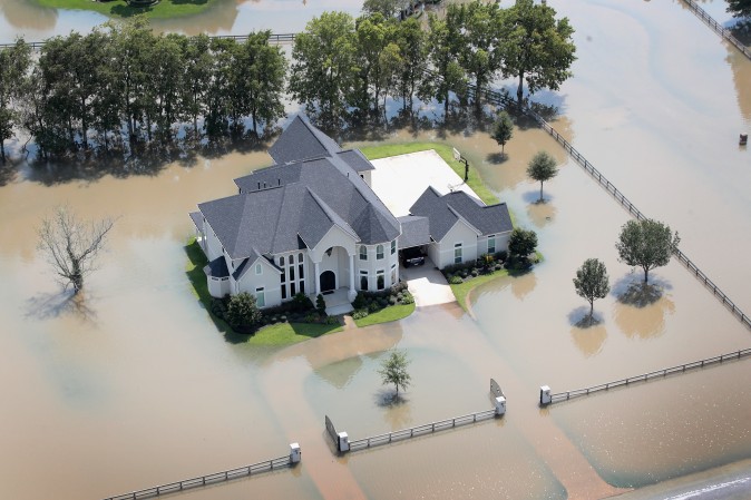 A mansion surrounded by floodwater after torrential rains pounded Southeast Texas is seen on August 31, 2017 near Sugar Land, Texas. While tempting for looters, law enforcement agencies are pledging increased penalties and determined prosecutions for crimes like looting and burglary committed in the wake of Hurricane Harvey. (Scott Olson/Getty Images)