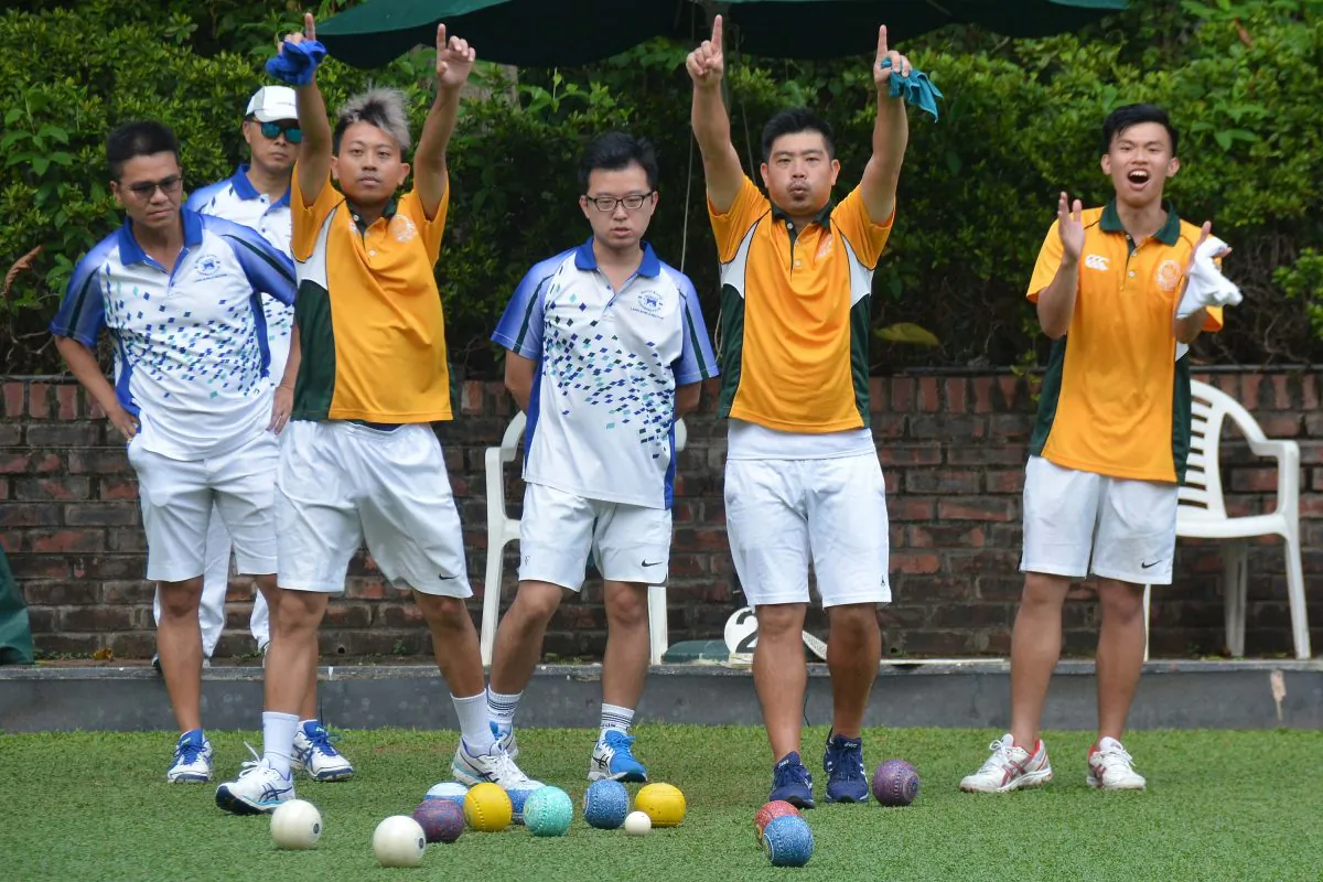 Wong Chun Yat (left in yellow) and Bronson Fung of Craigengower Cricket Club applaud a shot from their skipper during the league match against leaders Hong Kong Football Club last weekend, Sept 23, 2017. The rink won the game comfortably and helped CCC to an 8-0 victory. (Stephanie Worth)