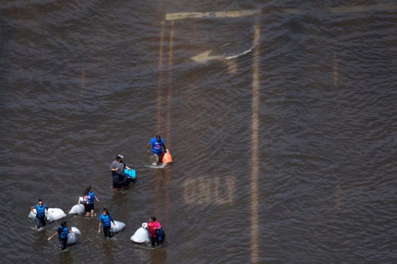 A group of people carry supplies through flood waters caused by Tropical Storm Harvey in Port Arthur, Texas, U.S. August 31, 2017. (REUTERS/Adrees Latif)