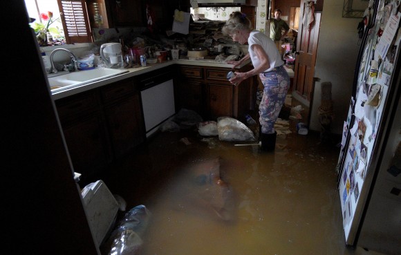 Nancy McBride collects items from her flooded kitchen as she returned to her home for the first time since Harvey floodwaters arrived in Houston, Texas September 1, 2017. (REUTERS/Rick Wilking)
