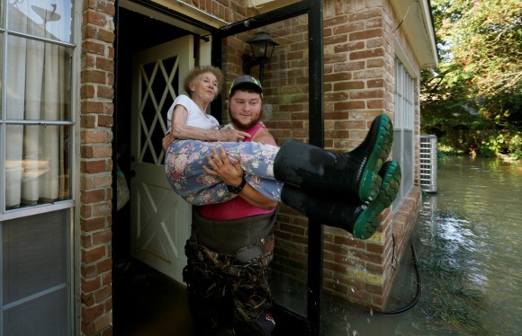 Nancy McBride is carried out of her flooded home by volunteer Cody Collinsworth, after returning home for the first time since Harvey floodwaters arrived in Houston, Texas September 1, 2017. (REUTERS/Rick Wilking)