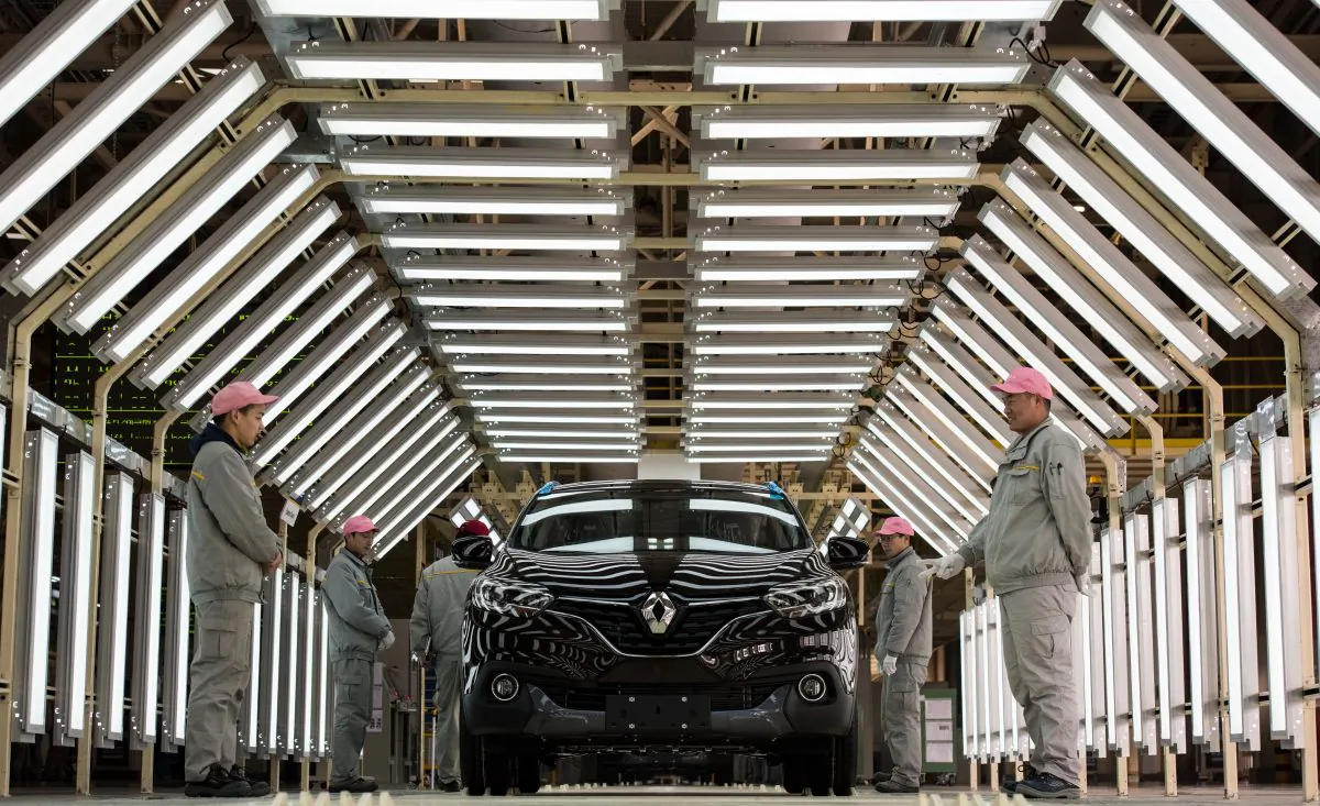 Chinese workers stand next to a Renault car on a production line of the Renault-Dongfeng factory in Wuhan, Hubei Province, on Feb. 1, 2016. (Johannes Eisele/AFP/Getty Images)