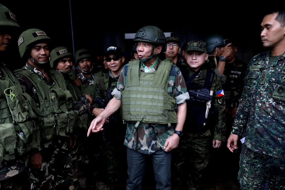 FILE PHOTO: Philippine President Rodrigo Duterte wears a bulletproof vest and a helmet as he gives a pep talk to troops fighting the extremist Maute group in Marawi, Philippines August 24, 2017. Picture taken August 24, 2017. Presidential Palace/Handout via (Reuters/File Photo)