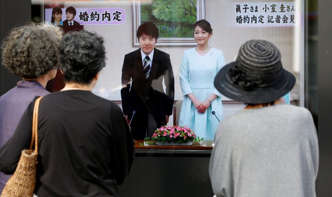 People look at a street monitor showing a news report about the engagement of Princess Mako, the elder daughter of Prince Akishino and Princess Kiko, and her fiancee Kei Komuro, a university friend, in Tokyo, Japan on September 3, 2017. (REUTERS/Toru Hanai)