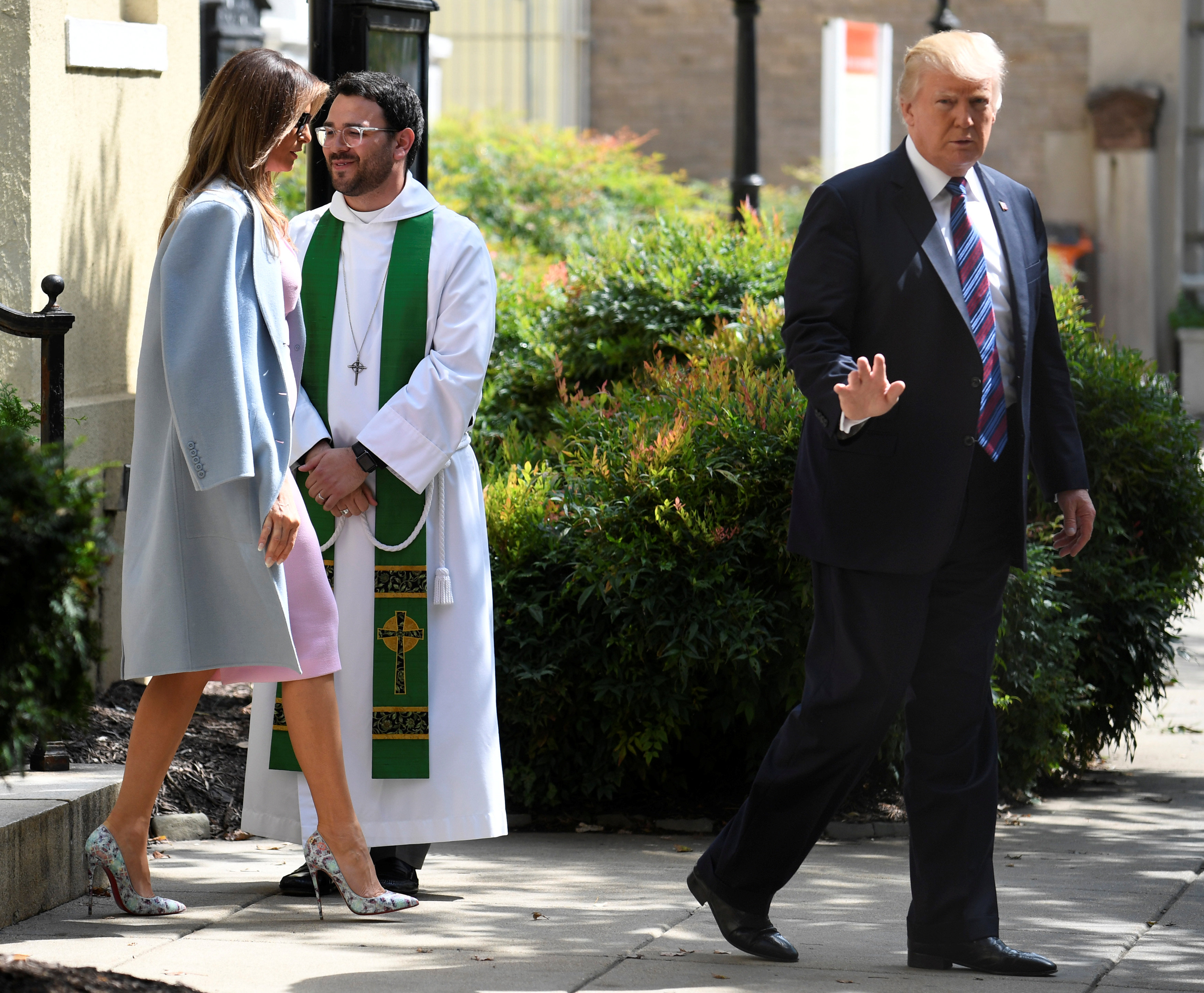 President Donald Trump waves to the press, as he departs St. John's Episcopal Church and Assistant Rector D. Andrew Olivo, (C), with First Lady Melania Trump after they attended services for a national "Day of Prayer", for victims of the Hurricane Harvey flooding in Texas, in Washington on Sept.3, 2017. (REUTERS/Mike Theiler)