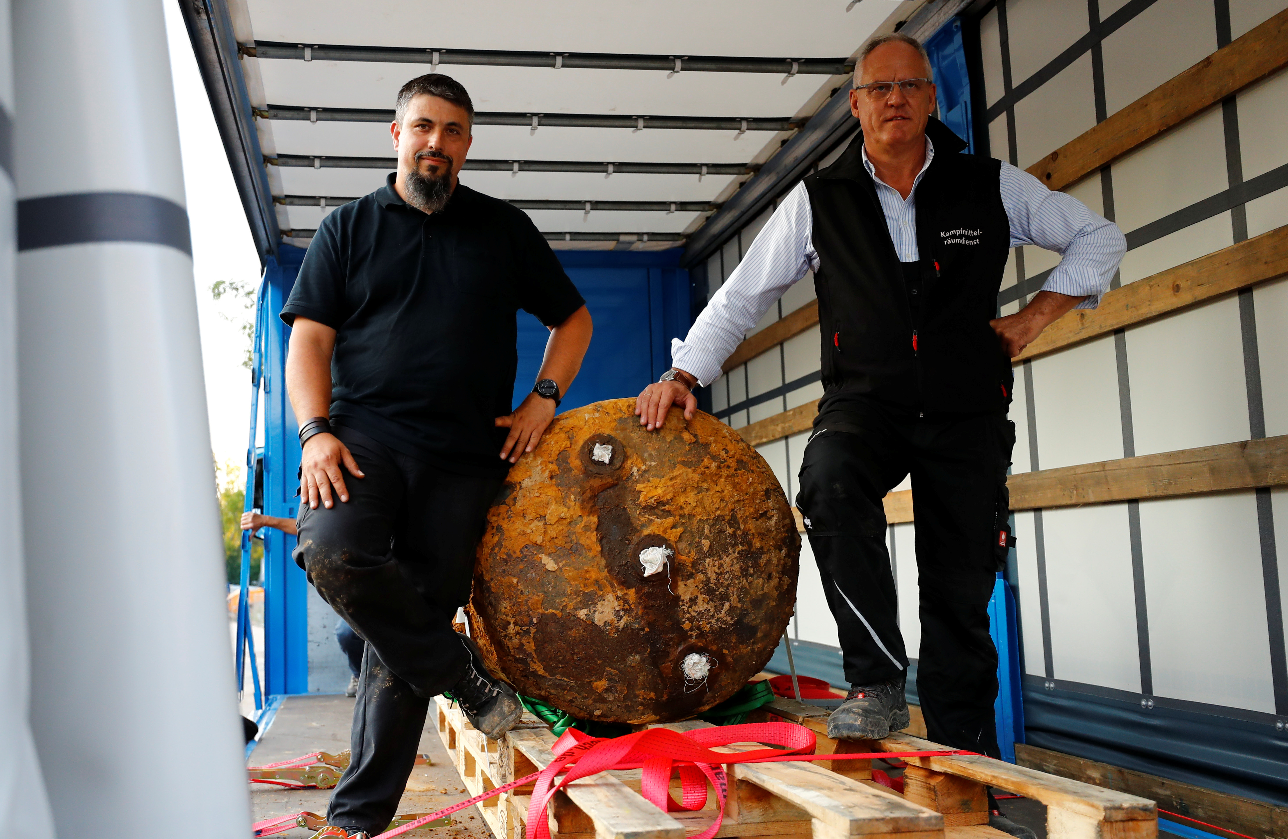 Bomb disposal experts Rene Bennert and Dieter Schweizler pose next to defused massive World War Two bomb after tens of thousands of people evacuated their homes in Frankfurt, Germany on Sept. 3, 2017. (REUTERS/Kai Pfaffenbach)