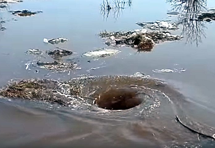 Watch this mesmerizing vortex in a Portuguese lake swallow excess rainwater